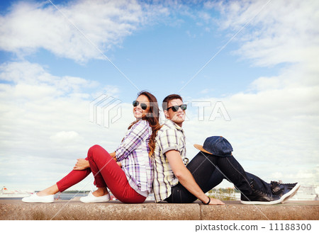 teenagers sitting back to back 11188300