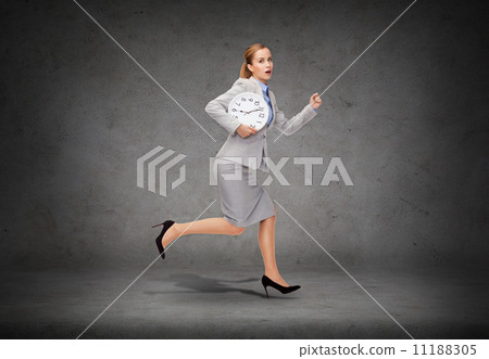 stressed young businesswoman with clock running stressed young businesswoman with clock running 11188305