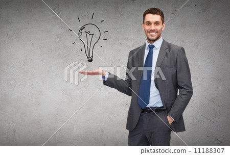 man showing light bulb on the palm of his hand 11188307