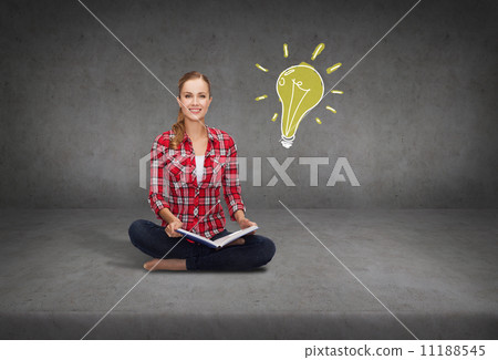 smiling young woman sittin on floor with book smiling young woman sittin on floor with book 11188545