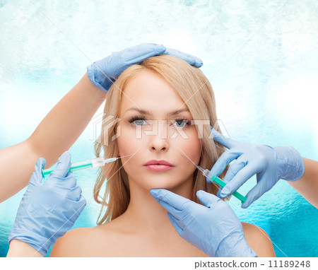 woman face and beautician hands with syringes 11189248