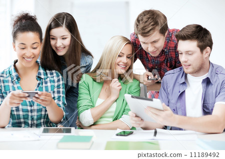 students looking at smartphones and tablet pc 11189492