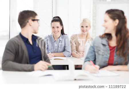 two teenagers with notebooks and book at school two teenagers with notebooks and book at school 11189722