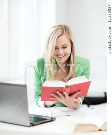 smiling student girl reading book in college 11189887