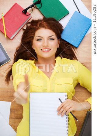 smiling female student with textbook and pencil smiling female student with textbook and pencil 11190288