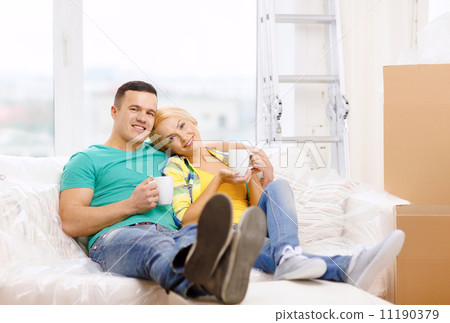 smiling couple relaxing on sofa in new home smiling couple relaxing on sofa in new home 11190379