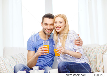 smiling happy couple at home drinking juice smiling happy couple at home drinking juice 11190453