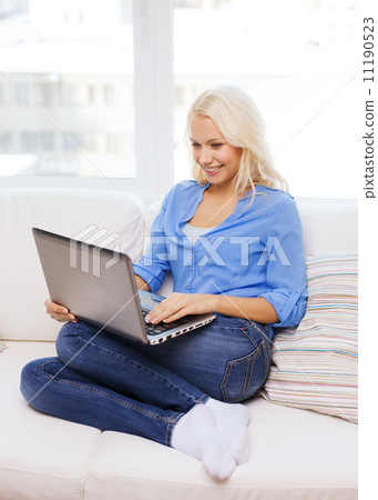 smiling woman with laptop computer at home smiling woman with laptop computer at home 11190523