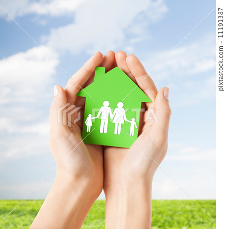 hands holding green house with family 11191387