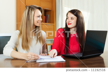 Smiling women looking financial documents Smiling women looking financial documents 11192516