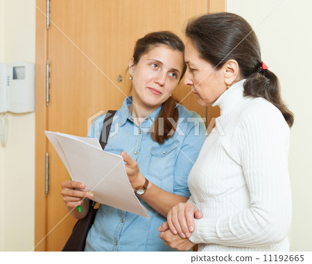 businesswoman trying to collect money from housewife 11192665