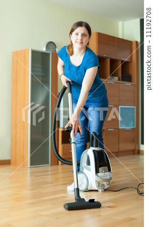 Woman cleans with vacuum cleaner Woman cleans with vacuum cleaner 11192708