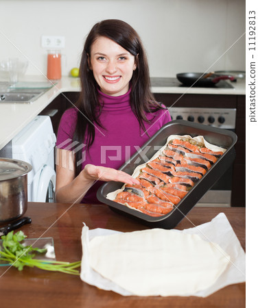 happy woman cooking fish pie in baking sheet happy woman cooking fish pie in baking sheet 11192813