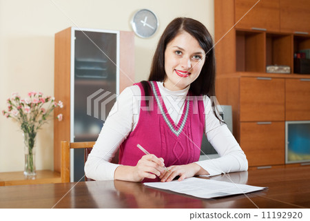 Smiling brunette woman staring financial documents 11192920