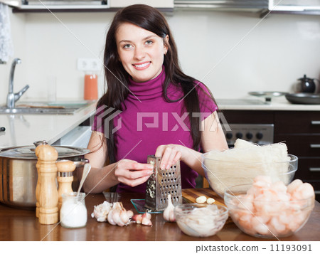 woman grating garlic on grater for noodles with seafood woman grating garlic on grater for noodles with seafood 11193091