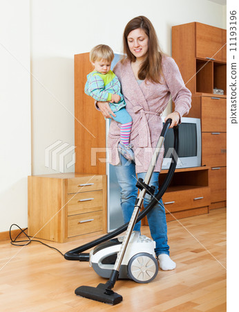 Mother with baby cleaning home 11193196