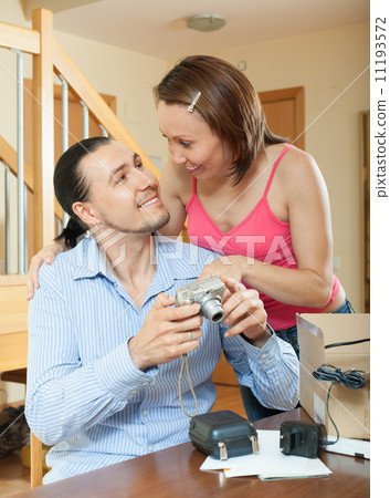 couple unpacking new compact digital camera couple unpacking new compact digital camera 11193572