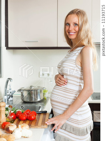 Pregnant girl cooking tomatoes 11193715