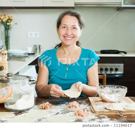 Mature housewife making meat dumplings Mature housewife making meat dumplings 11194017