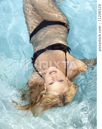 active young blonde woman in a blue pool 11206529
