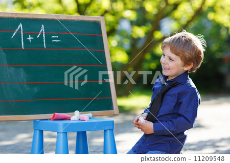 Little boy at blackboard practicing mathematics Little boy at blackboard practicing mathematics 11209548