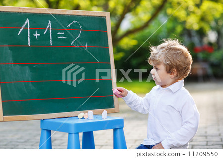 Little boy at blackboard practicing mathematics Little boy at blackboard practicing mathematics 11209550