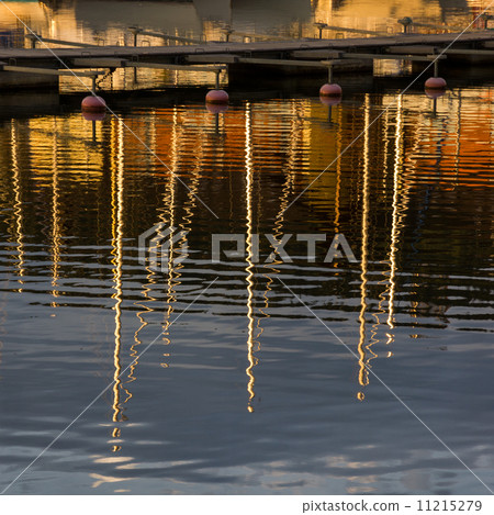 Water reflections at sunset. Masts of yachts reflected in water. 11215279