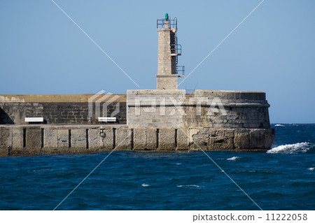 Stone Lighthouse over ocean and blue sky Stone Lighthouse over ocean and blue sky 11222058