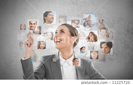 Young successful business woman looking at people portraits. Int Young successful business woman looking at people portraits. Int 11225720