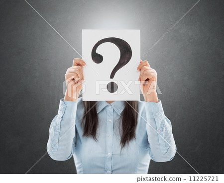 Young woman holding interrogation symbol in front of her face 11225721