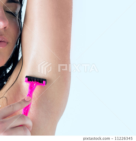 Portrait of young female shaving her armpit Portrait of young female shaving her armpit 11226345