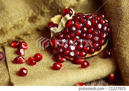 Raw pomegranate with seeds on sacking 11227625