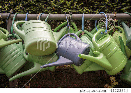 some old watering cans on a rusty pipe some old watering cans on a rusty pipe 11228824