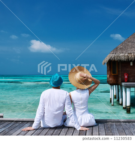 Couple on a beach jetty at Maldives Couple on a beach jetty at Maldives 11230583