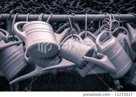 some old watering cans on a rusty pipe 11233017