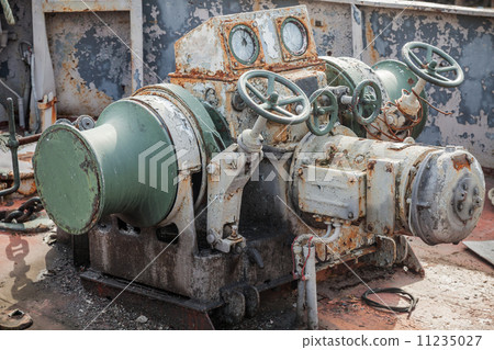 Rusted bow anchor winch on abandoned ship 11235027