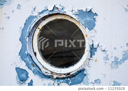 Round porthole in white and blue ship wall 11235028