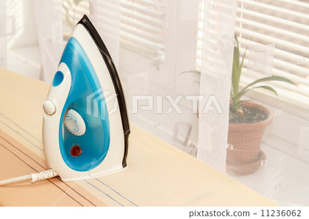 view of modern iron on ironing board view of modern iron on ironing board 11236062