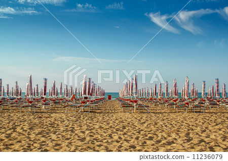 withdrawn umbrellas and sunlongers on the sandy beach 11236079