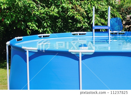 Circular water pool at garden with chlorine float and ladder. 11237825