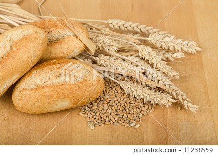 roll on wooden table with ears of wheat grain roll on wooden table with ears of wheat grain 11238559