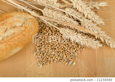 roll on wooden table with ears of wheat grain roll on wooden table with ears of wheat grain 11238560
