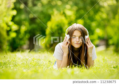 Girl smiling with pleasure as she listens to music Girl smiling with pleasure as she listens to music 11238675
