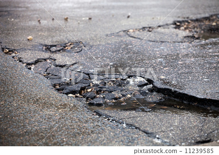 Broken pavement and pothole asphalt road after winter. 11239585