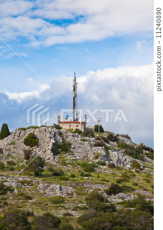 A radio communications tower on a stone hill 11240890