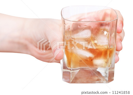 hand holds whiskey on ice in glass isolated 11241858