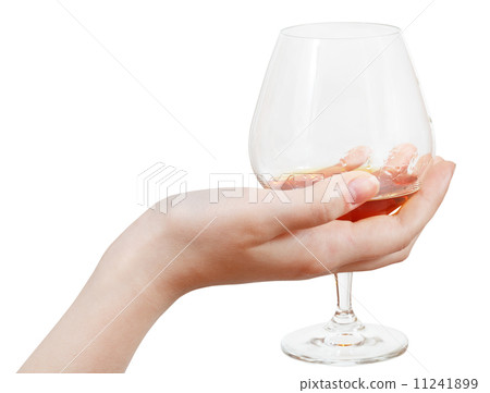glass goblet with brandy in hand isolated 11241899