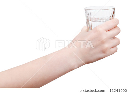hand holds mineral water in glass isolated 11241900