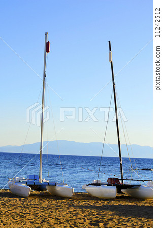 Sailboat Stands on the Beach Against the Blue Sea Sailboat Stands on the Beach Against the Blue Sea 11242512
