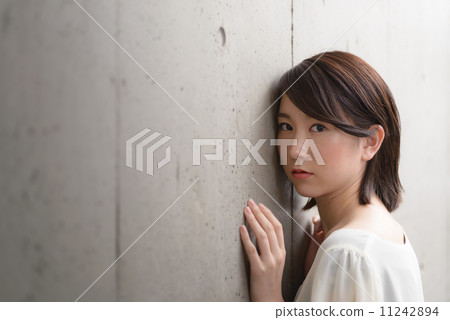 A woman leaning against the concrete wall 11242894